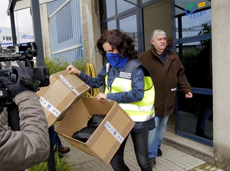 Agentes de la Policía salen con una persona esta mañana de la sede de la empresa Cespa en Santiago de Compostela que han registrado dentro de la Operación Patos 2