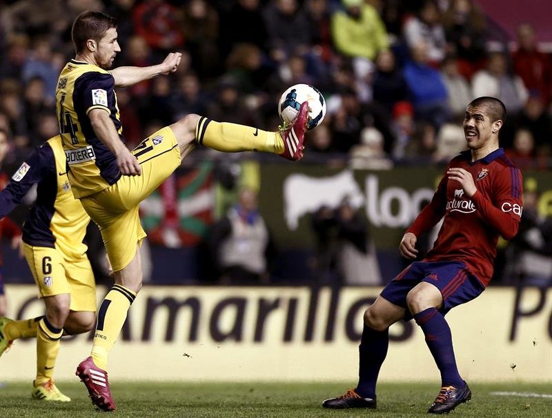 El centrocampista del Atlético de Madrid Gabi (i) trata de controlar un balón ante el chileno Silva, de Osasuna