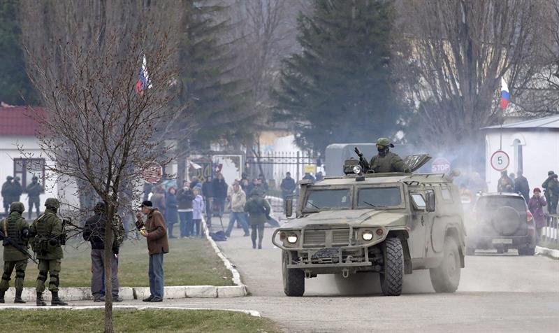 Tropas rusas y civiles prorrusos, a las puertas de una base militar en Crimea.