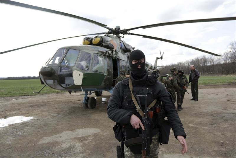 Varios soldados ucranianos vigilan cerca de un helicóptero 