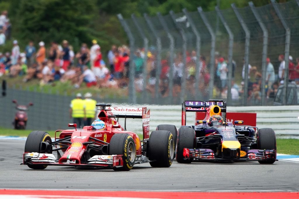 Fernando Alonso pilota su Ferrari por delante del Red Bull de Vettel, ayer en el Gran Premio de Alemania.