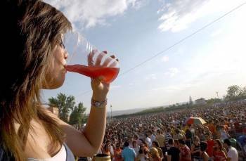 Una joven consume alcohol en un botellón durante el verano.