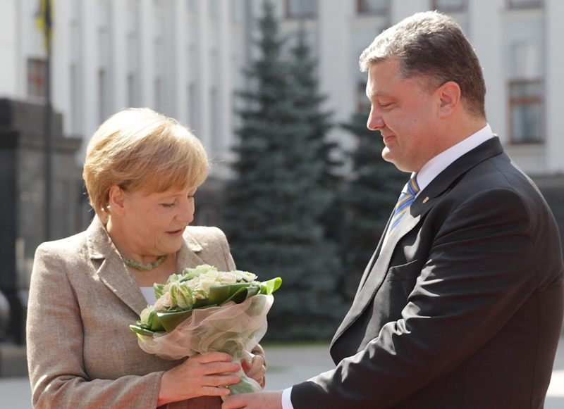 Poroshenko recibe con un ramo de flores a Angel Merkel, ayer en Kiev.