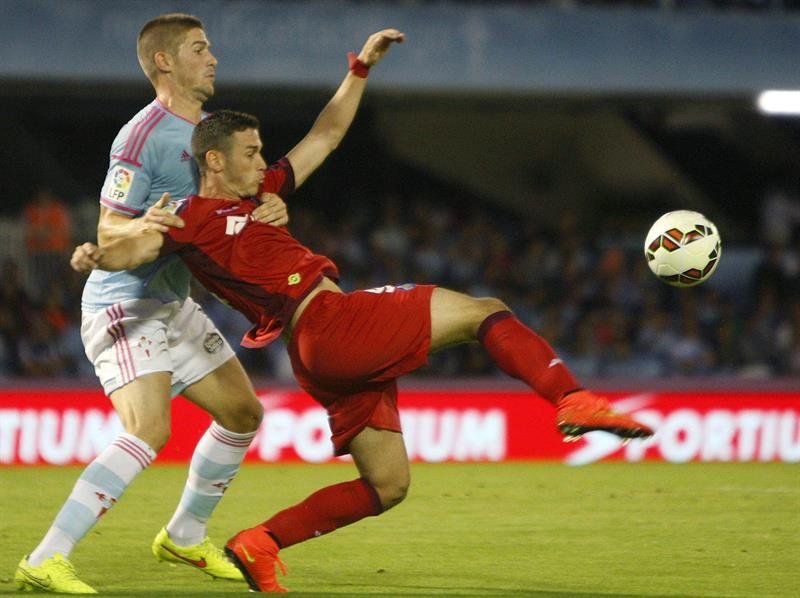 El defensa del Celta de Vigo Andreu Fontás (i) pugna por un balón con Álvaro Vázquez, del Getafe