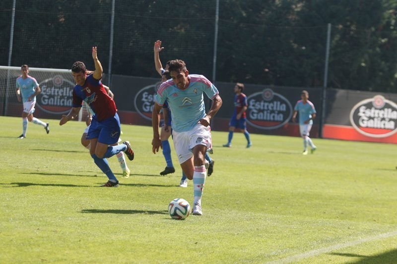 Borja Iglesias conduce el balón durante el partido contra el Langreo en el campo de Barreiro.