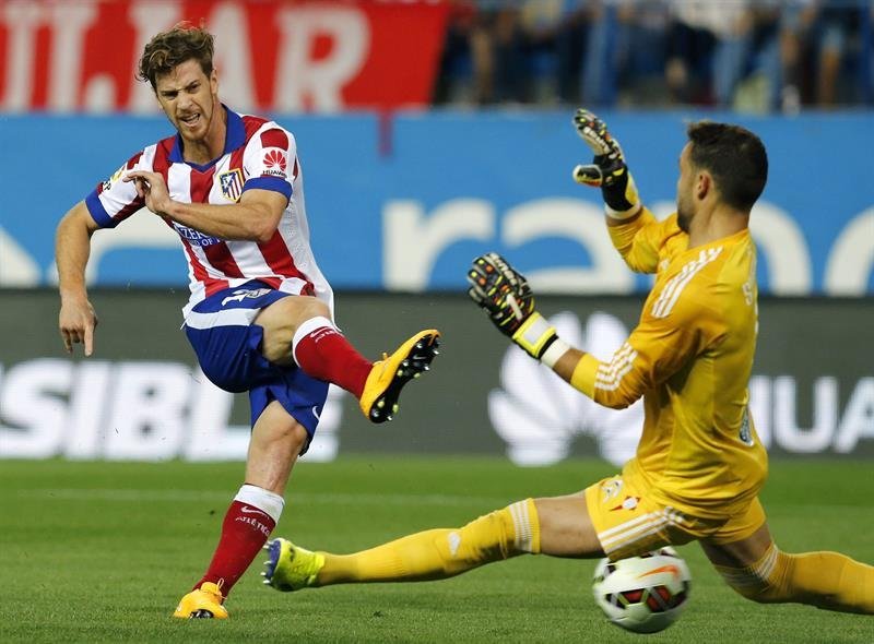 El lateral argentino del Atlético de Madrid Cristian Ansaldi (i) chuta ante el portero Sergio Álvarez, del Celta de Vigo