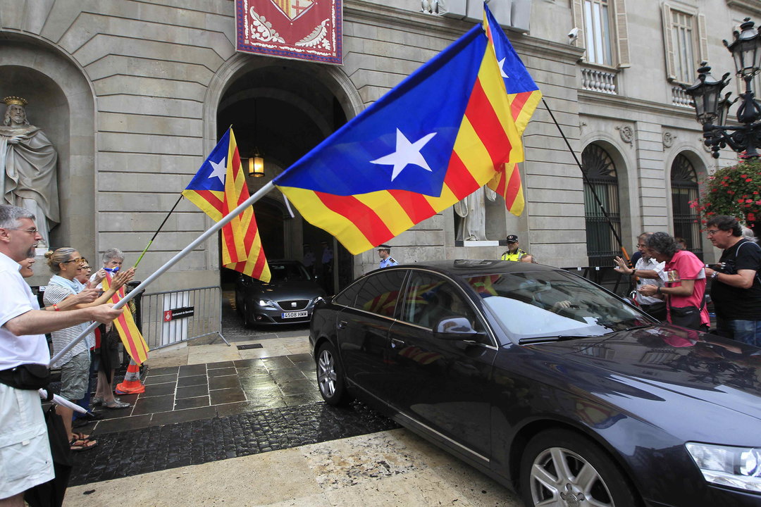 Un grupo de independentistas saluda con banderas al coche del alcalde de Barcelona, Xavier Trías.
