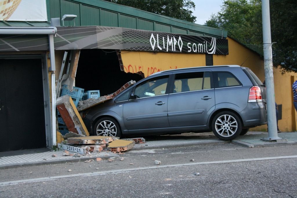 El coche acabó con parte del muro del establecimiento, debido al impacto.