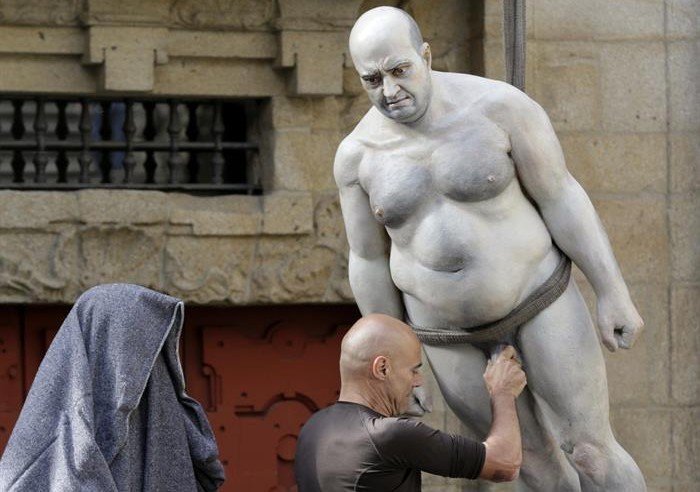 El escultor Ramón Conde (c), durante la retirada de las esculturas de su muestra "O Poder", que ha suscitado la polémica de turistas y la queja del Cabildo, esta mañana en Santiago de Compostela. (EFE)