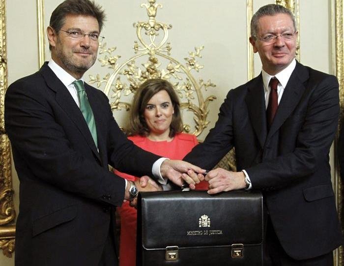 El nuevo ministro de Justicia, Rafael Catalá (i), recibe su cartera ministerial de manos de su antecesor en el cargo, Alberto Ruiz-Gallardón