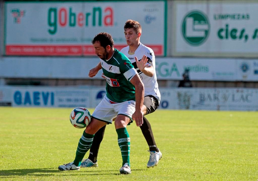 Antúnez, capitán del Coruxo, protege el balón ante un rival en un partido de esta temporada en O Vao.