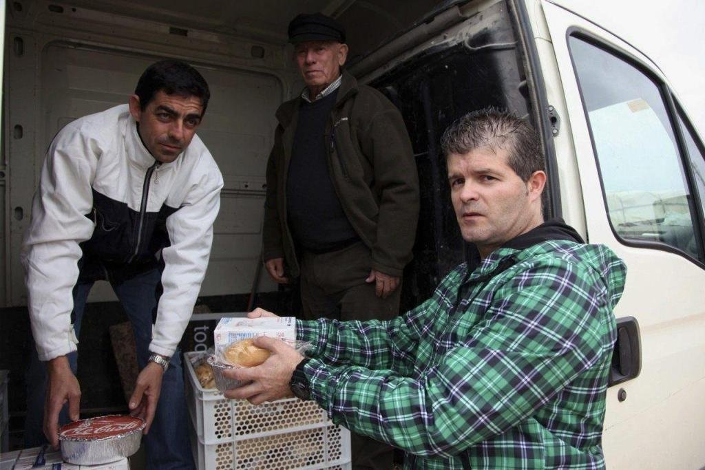 Un voluntario reparte comida a un indigente en Andalucía.