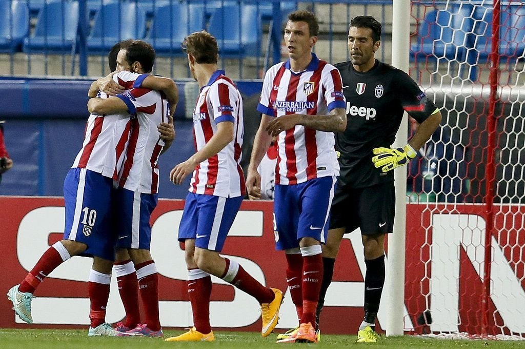 Los jugadores del Atlético celebran su gol en presencia del portero de la Juventus, Buffon.