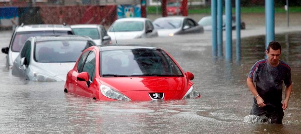 Un trabajador de Citroën intenta recuperar su coche en las inmediaciones de Balaídos, donde los vehículos quedaron sumergidos ya que el agua alcanzó un metro de altura junto al estadio.