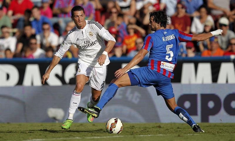 El delantero portugués del Real Madrid Cristiano Ronaldo (i), pelea un balón con el defensa del Levante UD Héctor Rodas