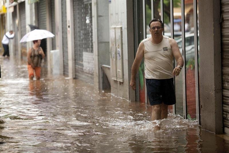 Un hombre camina por una de las calles de Santa Cruz de Tenerife inundadas