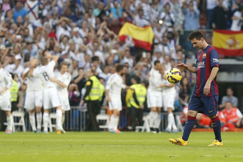 Leo Messi se dirige con el balón al centro del campo mientras los jugadores del Real Madrid celebran el 2-1 contra el Barcelona.
