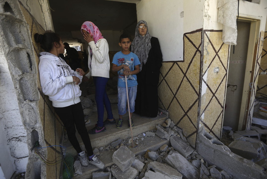 Familiares de Abed al-Rahman al-Shaludi observan la casa, destrozada por tropas israelíes.