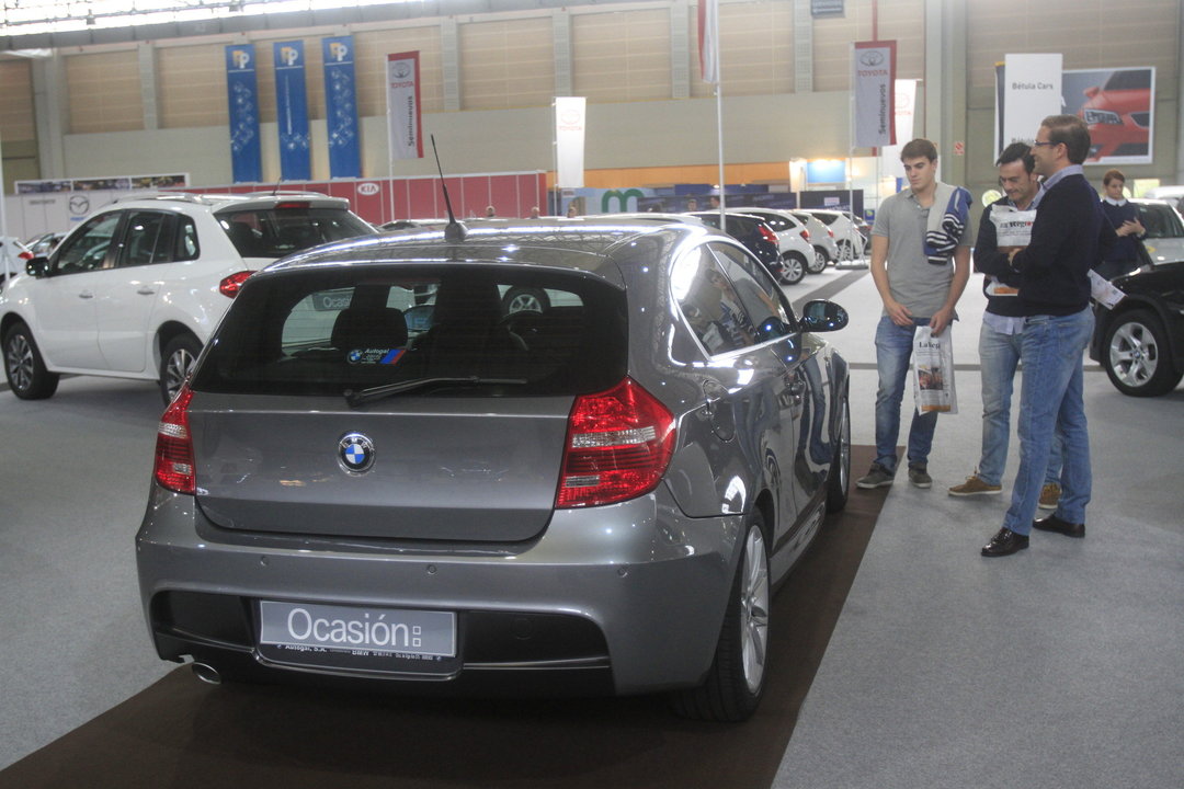 Dos visitantes a la última edición del salón del automóvil de Expourense examinan un vehículo.