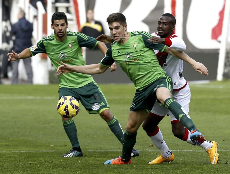 Andreu Fontás protege el balón ante la presencia del rayista Kakuta, con Nolito al fondo.