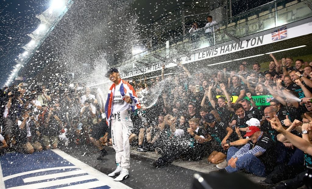 El británico Lewis Hamilton celebra junto a los miembros del equipo Mercedes el título mundial que conquistó ayer al ganar el Gran Premio de Abu Dabi.