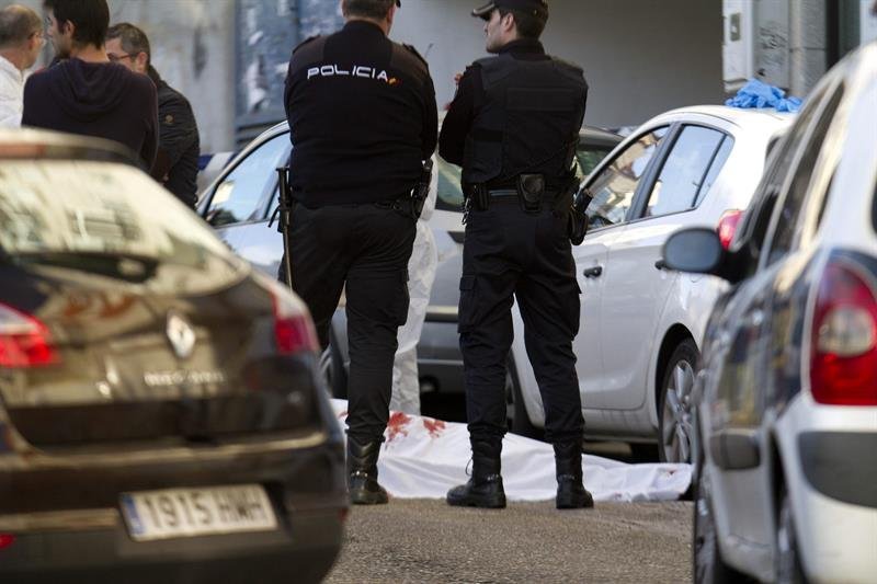 Efectivos de la Policía junto al cuerpo del atracador fallecido en el atraco a una entidad bancaria de Vigo