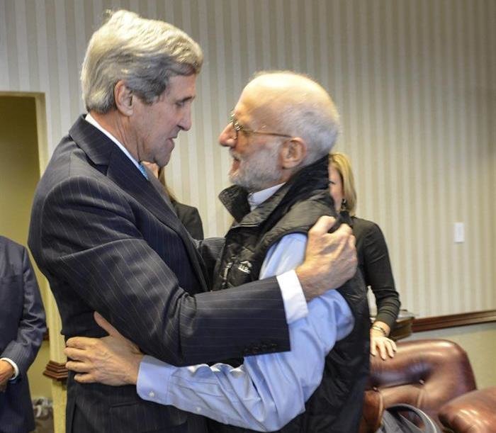 El secretario de Estado John Kerry (i) saludando al contratista estadounidense Alan Gross