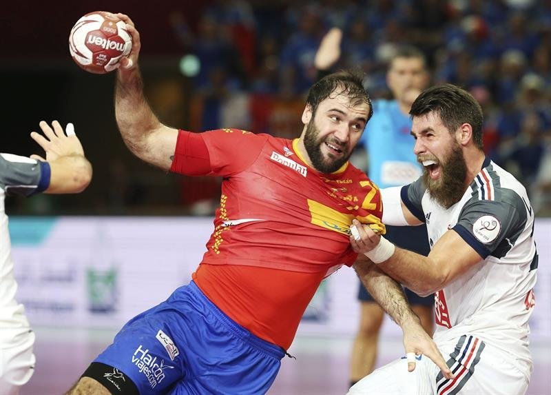 El jugador de la selección española de balonmano Joan Canellas pelea por el control del balón con el francés Luka Karabatic
