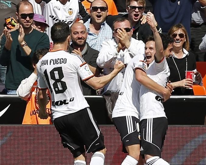 Javi Fuego y Parejo felicitan a Piatti, autor de los dos goles del Valencia.