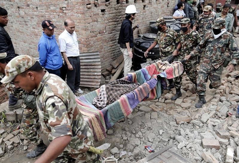 Varios soldados retiran un cadáver tras encontrarlo bajo los escombros de un edificio en Katmandú (Nepal)