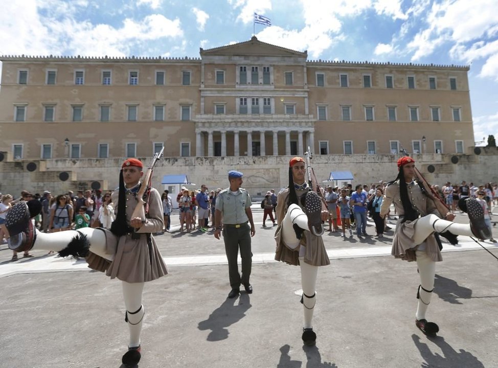 Grupos de turistas contemplan en Atenas el relevo de la guardia ante el Parlamento heleno.