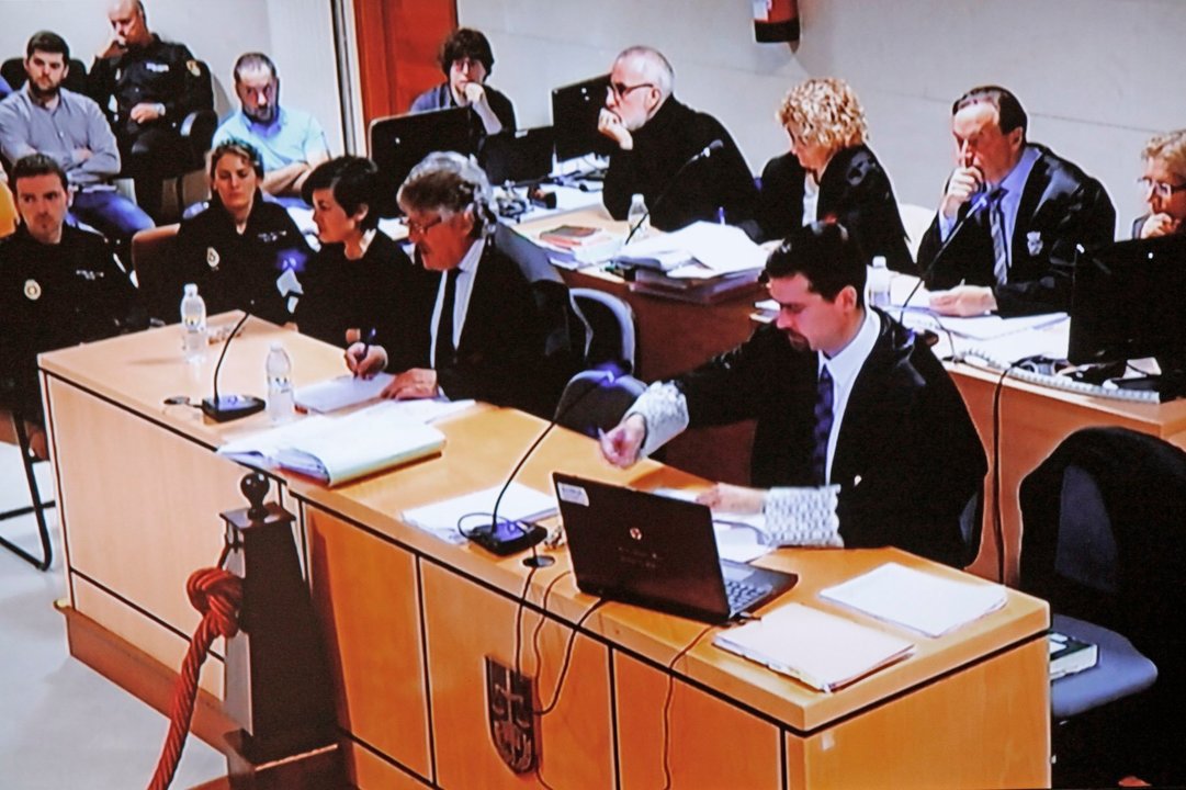 Rosario Porto y Alfonso Basterra, detrás, acompañados por sus abogados, en una imagen del vídeo de la sala de audiencias.