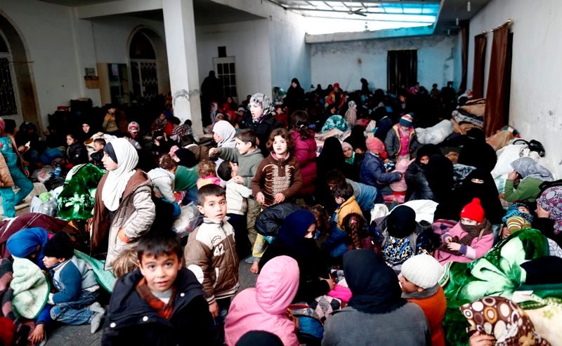 Mujeres y niños esperan para conseguir comida en Bab al Salama.