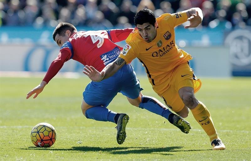 El delantero uruguayo del FC Barcelona Luis Suárez (d) lucha un balón con el defensa del Levante &#34;Toño&#34; García