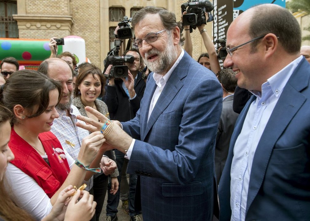 Rajoy se pone una pulsera solidaria en su visita ayer a Murcia.