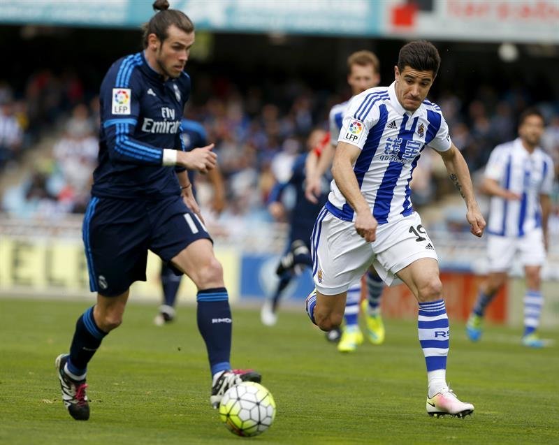 El defensa de la Real Sociedad Yuri Berchiche (d) lucha un balón con el centrocampista galés del Real Madrid Gareth Bale