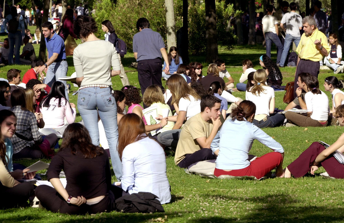 Un grupo de estudiantes universitarios descansan entre clases en un campus español.