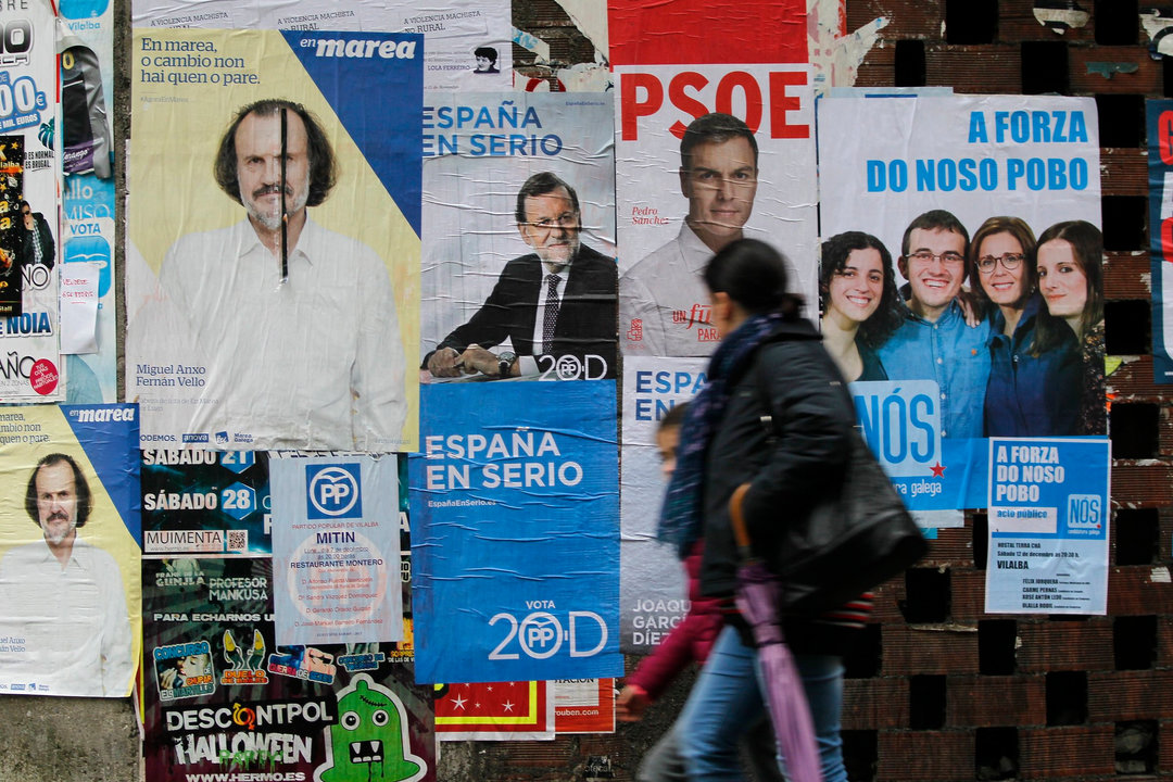Una mujer pasa ante una pared empapelada por carteles electorales, el pasado diciembre en Lugo.