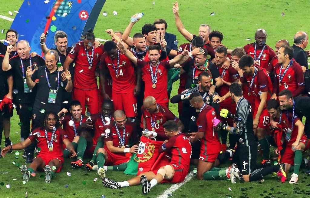 Jugadores y miembros del cuerpo técnico de la selección de Portugal celebran su victoria sobre el césped de Saint Denis tras derrotar a Francia en la final de la Eurocopa.