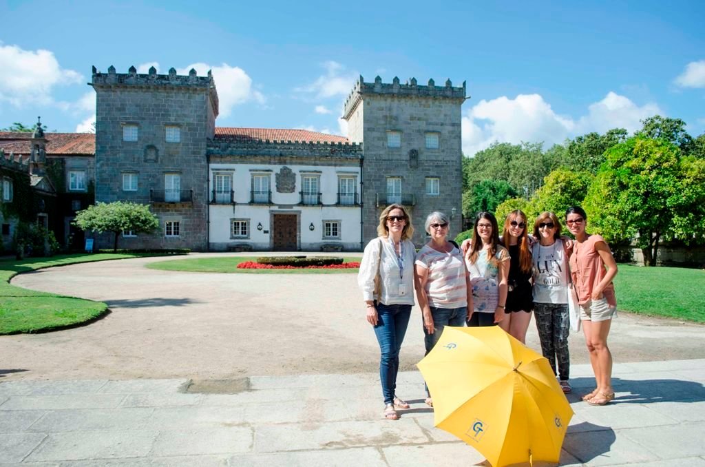 Algunas de las asistentes a la visita del viernes por el Pazo Quiñones de León con el paraguas amarillo, distintivo de la actividad.