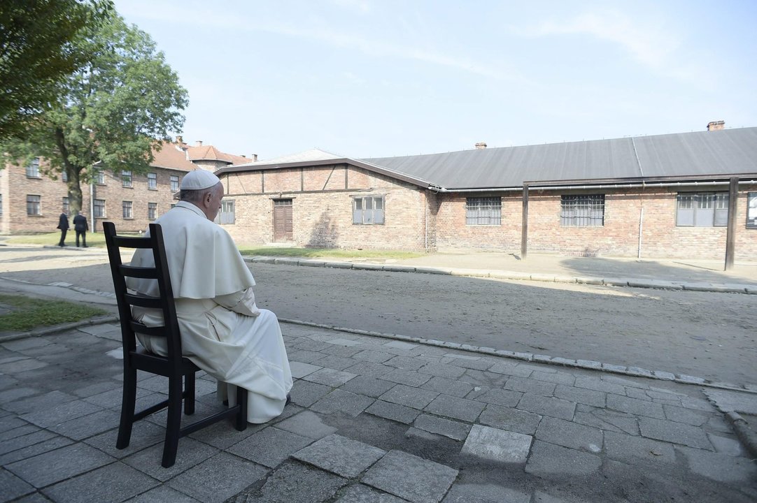 El papa Francisco sentado frente a un barracón durante su visita al campo de Auschwitz.