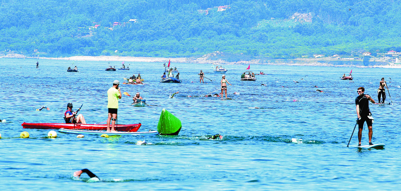 Nadadores pasando una de las boyas junto a las embarcaciones de control, en la edición de 2015.
