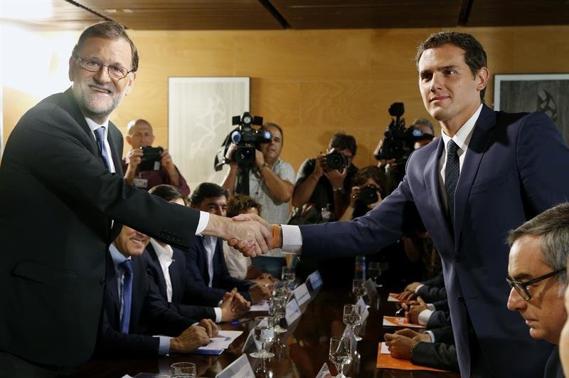 El jefe del Gobierno, Mariano Rajoy,iz., y el líder de Ciudadanos, Albert Rivera, se estrechan la mano