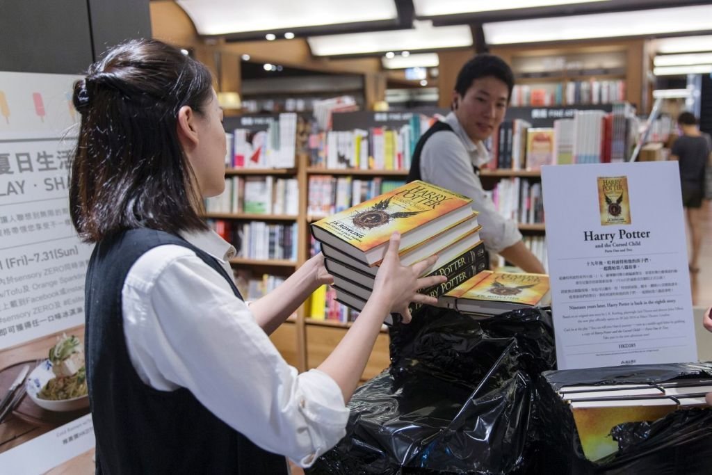 Una empleada de una tienda de Hong Kong, con ejemplares del nuevo libro de Harry Potter.