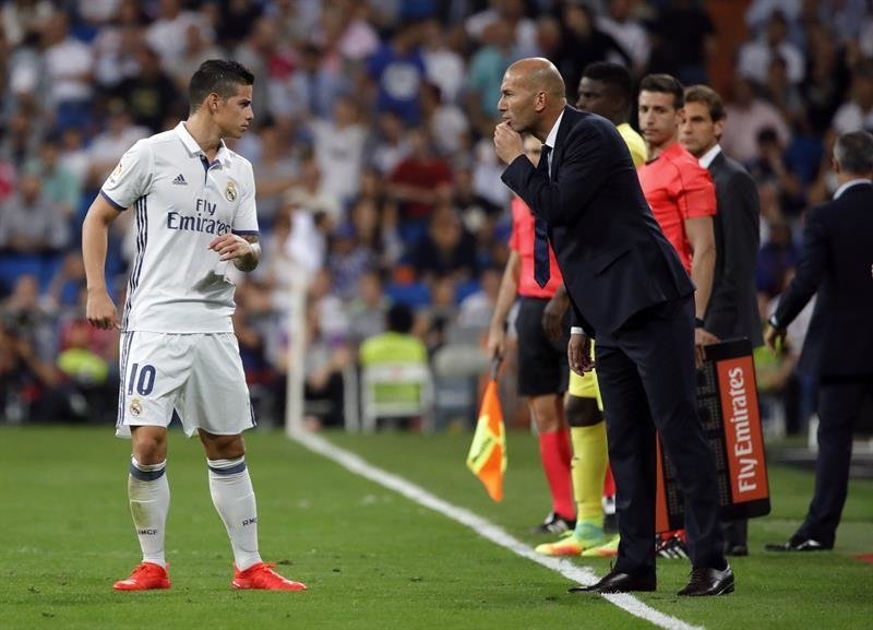 El entrenador francés del Real Madrid Zinedine Zidane (d) da indicaciones al colombiano James Rodríguez