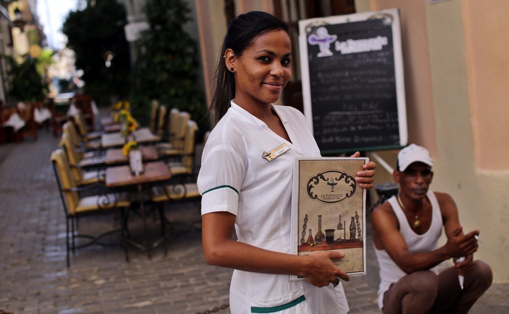 Una camarera espera clientes en un mesón privado en La Habana.