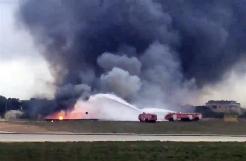 los bomberos que intentan extinguir las llamas en la avioneta Fairchild Metroliner Mark III en el aeropuerto de Luqa, Malta