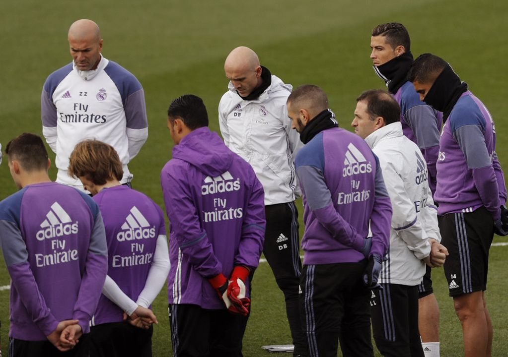 Jugadores y técnicos del Real Madrid guardan un minuto de silencio en el entrenamiento de ayer.