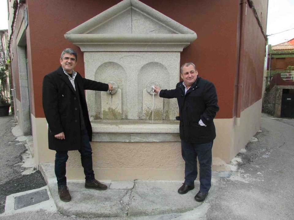 El alcalde guardés, Antonio Lomba (izquierda), muestra la antigua fuente recuperada para su uso.
