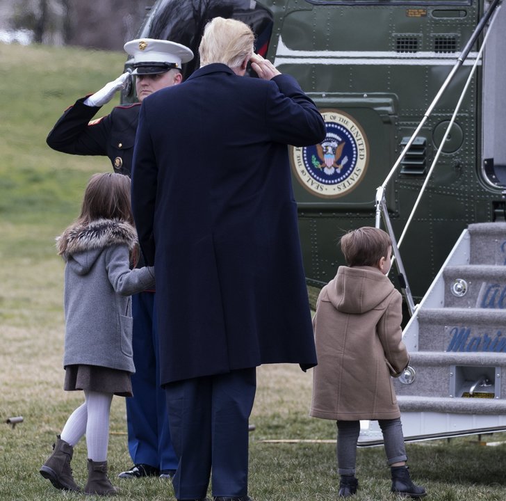 Trum, con sus nietos, recibe el saludo militar ante el Marine One.